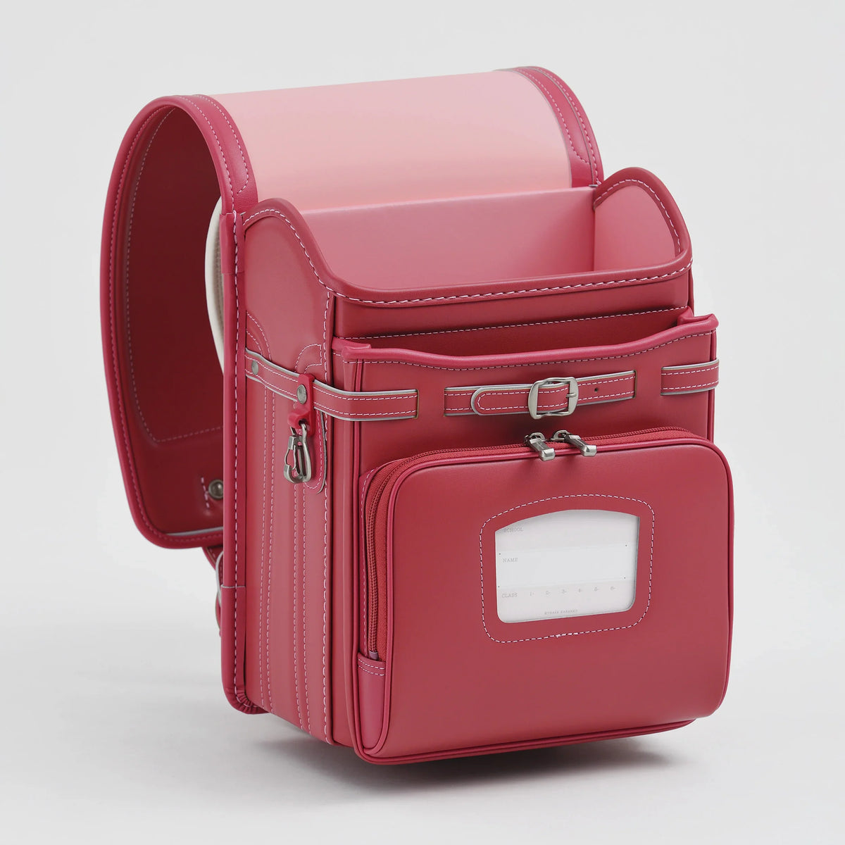 Bolca Randoseru by Murase Kabanko – pink Japanese randoseru backpack with front pocket and white stitching, standing on white background