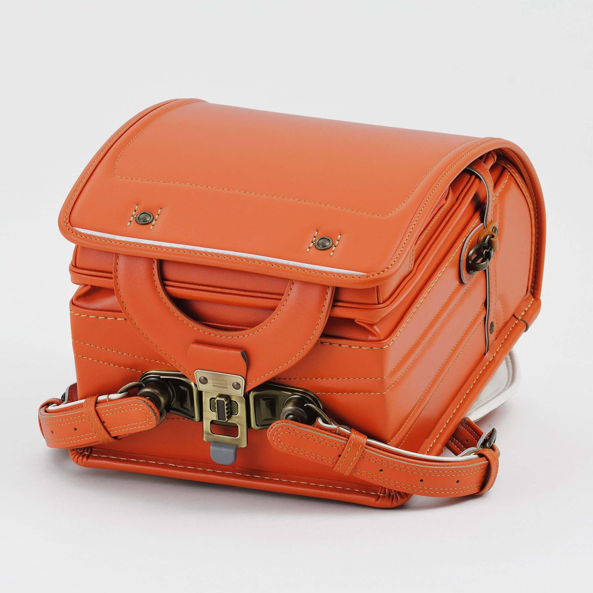 Bolca Randoseru by Murase Kabanko – orange Japanese Randoseru backpack with handle and classic metal clasp on white background