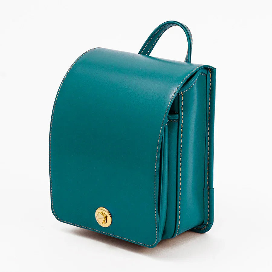 Teal Japanese Randoseru backpack with gold clasp, premium leather, on white background
