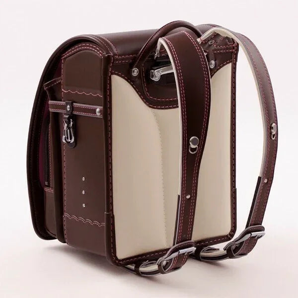 Brown and cream Japanese randoseru backpack with detailed stitching on white background