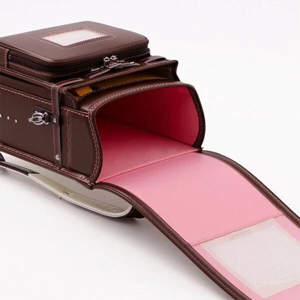 Japanese randoseru backpack in brown with pink interior, open and empty on white background