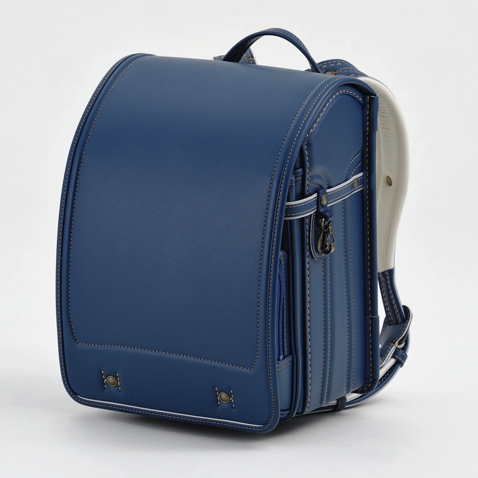 Blue Japanese randoseru backpack with white stitching on plain background