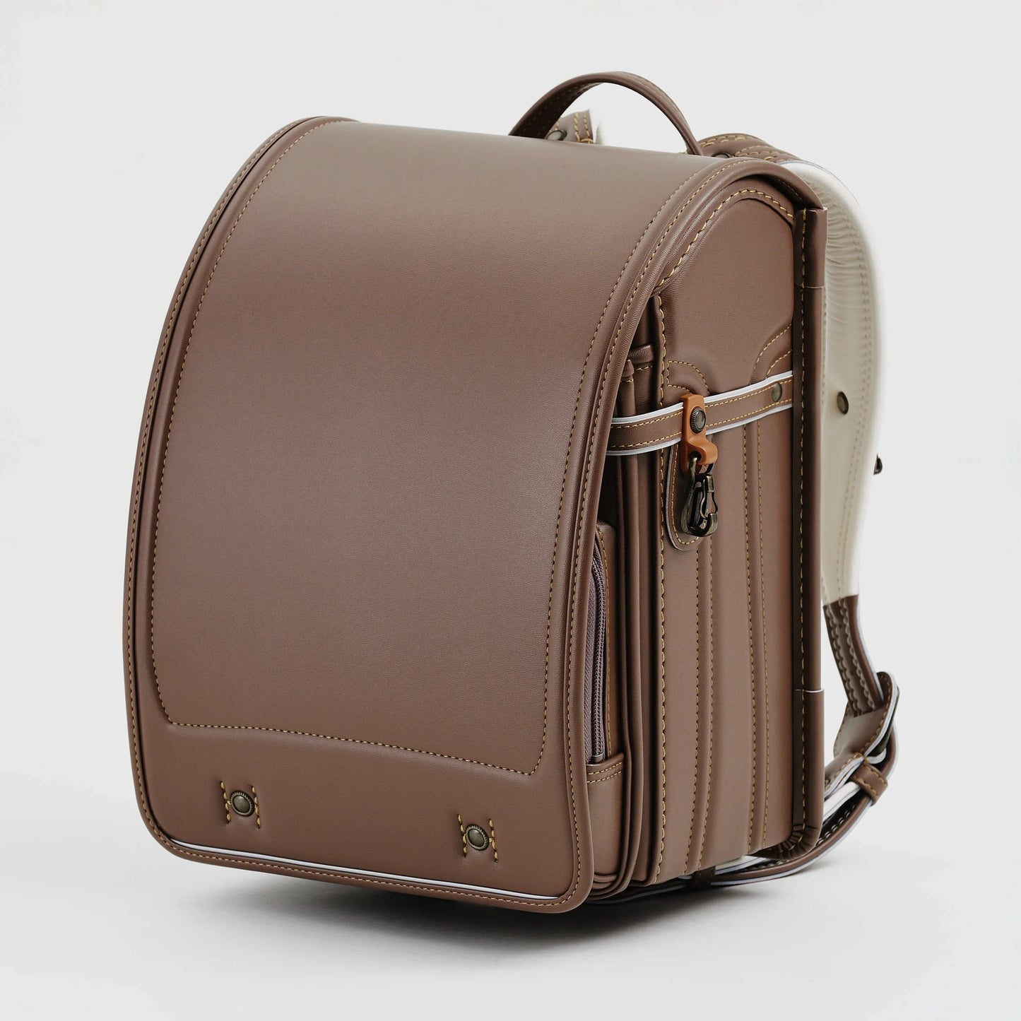 Brown Japanese randoseru backpack with cream accents, structured design on white background