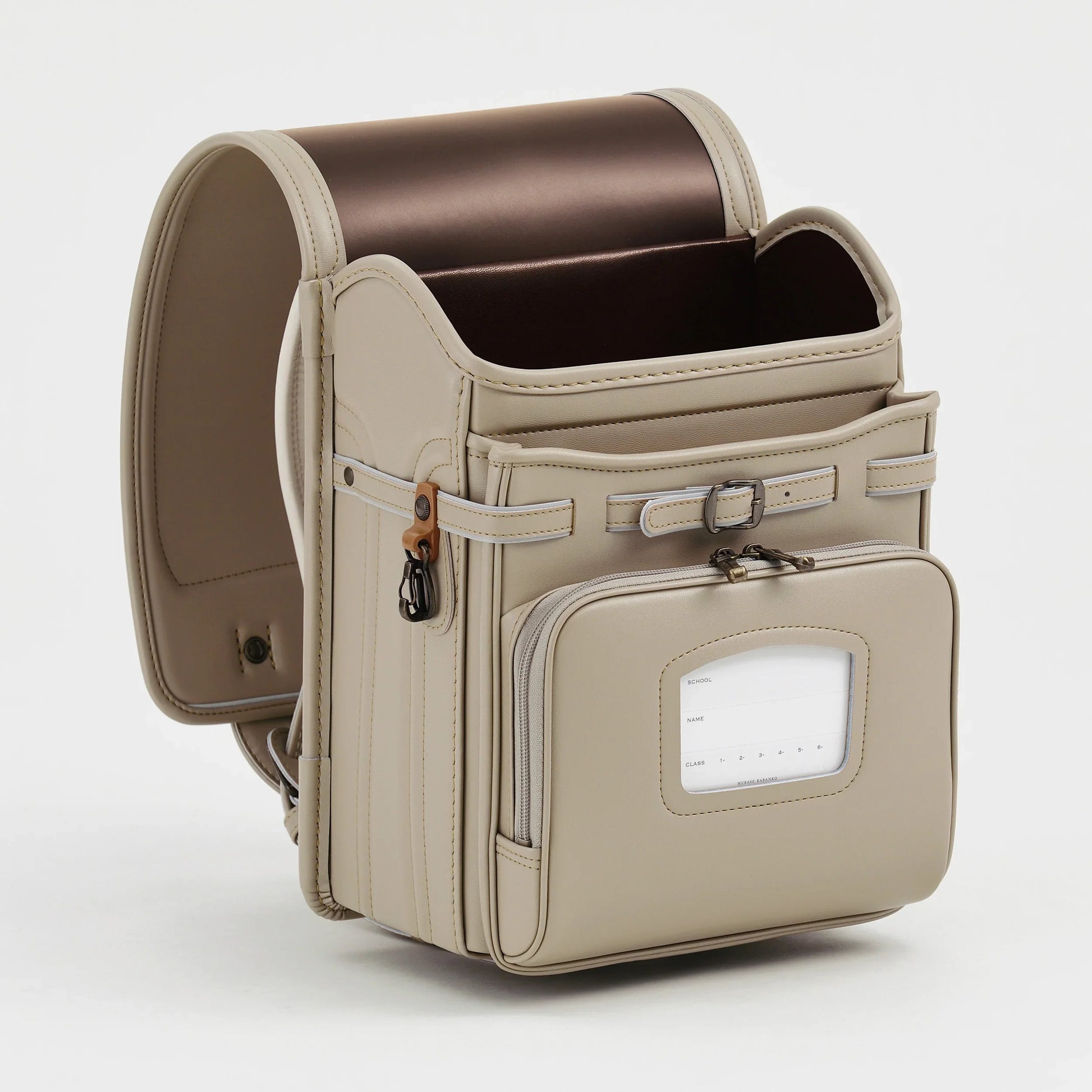 Beige Japanese randoseru backpack with front pocket and brown interior, standing upright