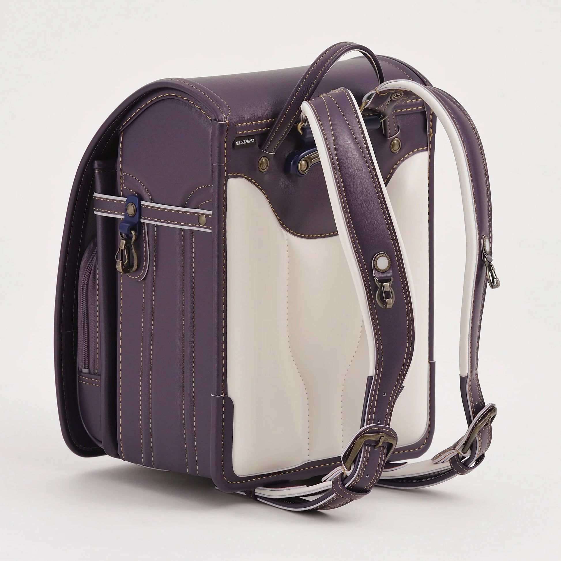 Purple and white Japanese randoseru backpack with padded straps, side pocket, and contrast stitching