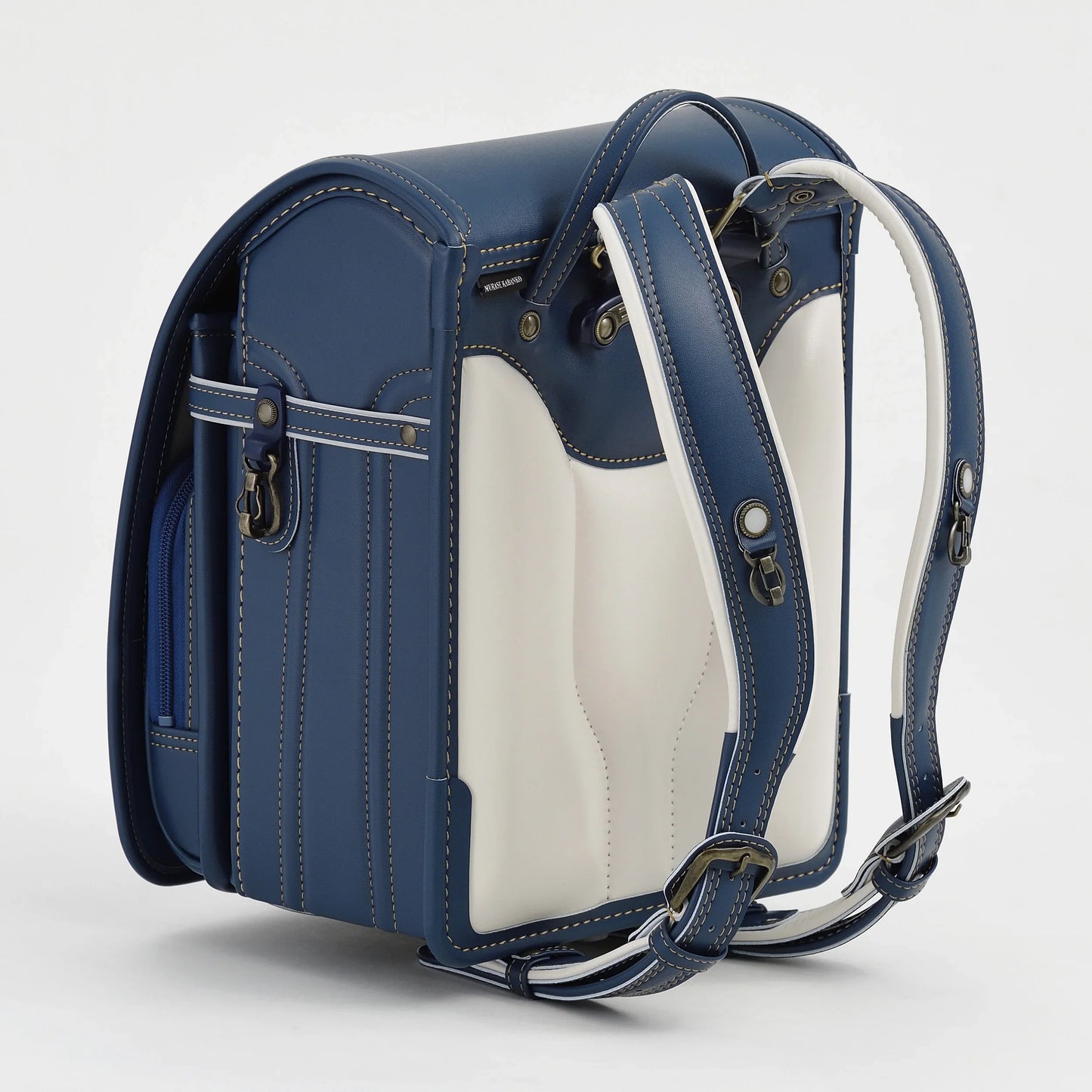 Japanese randoseru backpack in blue and white leather with padded straps on a white background