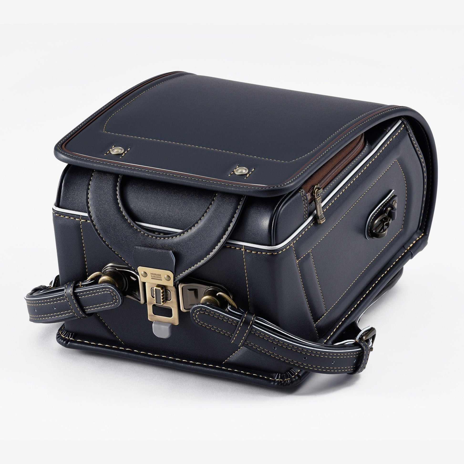 Navy Japanese randoseru backpack with tan stitching and metal clasp on white background