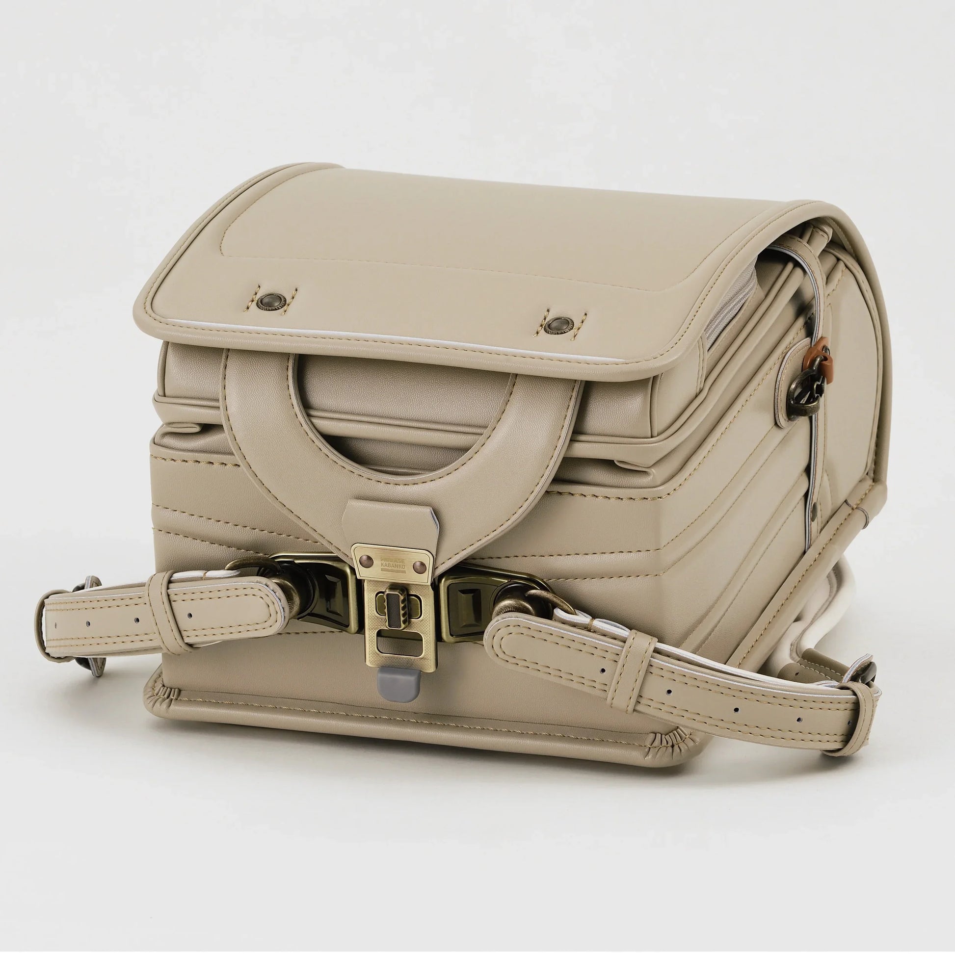 Beige Japanese randoseru backpack with metal clasp, shown from the front on white background