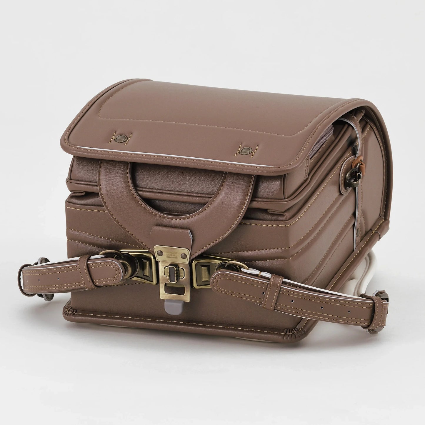 Brown Japanese Randoseru backpack with metal buckle on white background