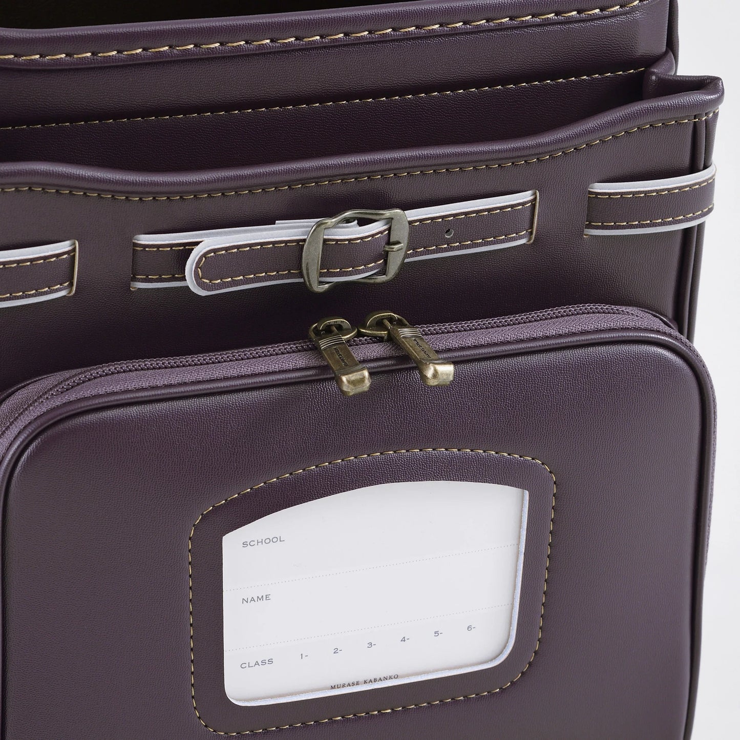 Close-up of a purple Japanese randoseru backpack with buckles and name tag pocket