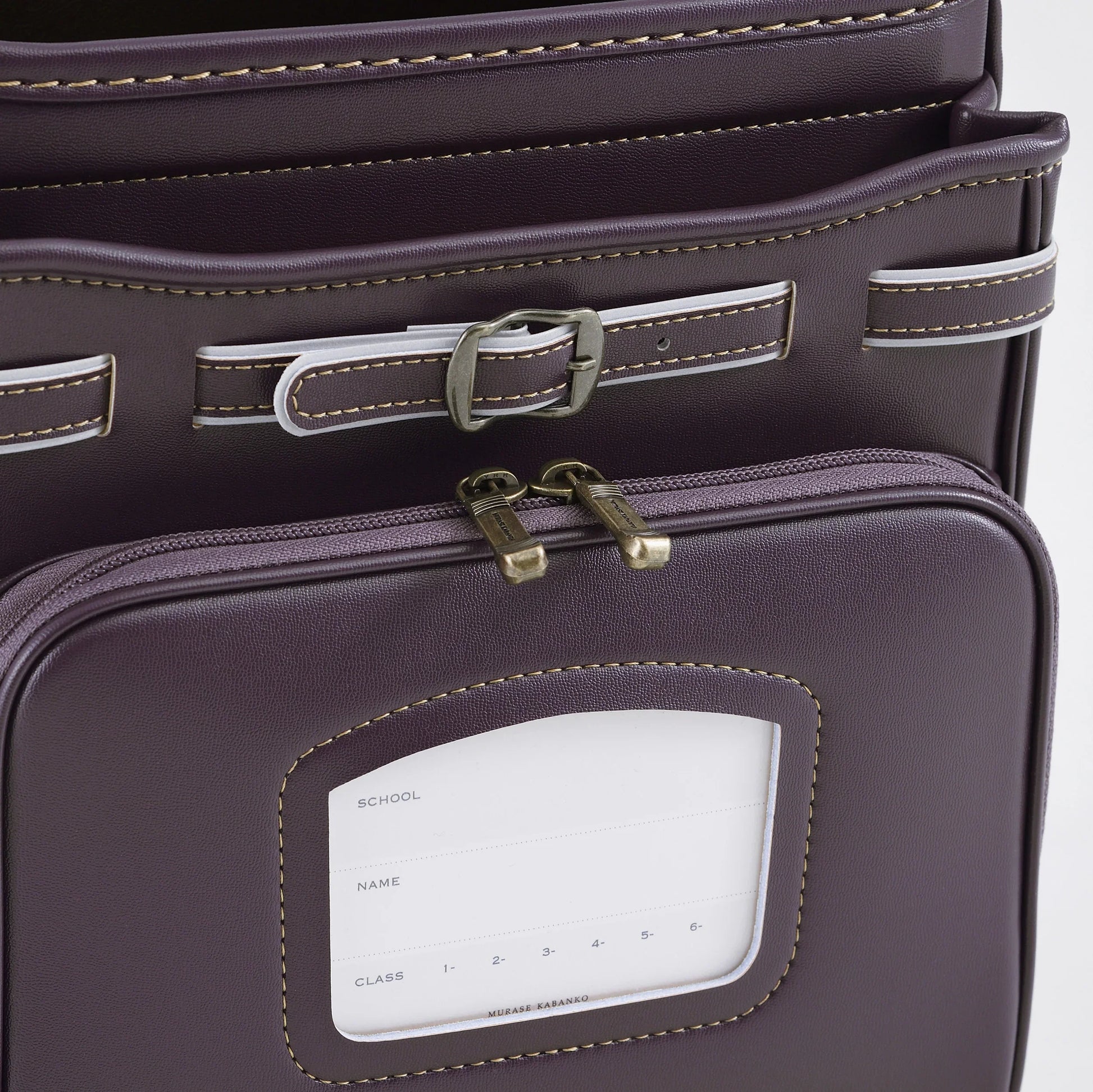 Close-up of a purple Japanese randoseru backpack with buckles and name tag pocket