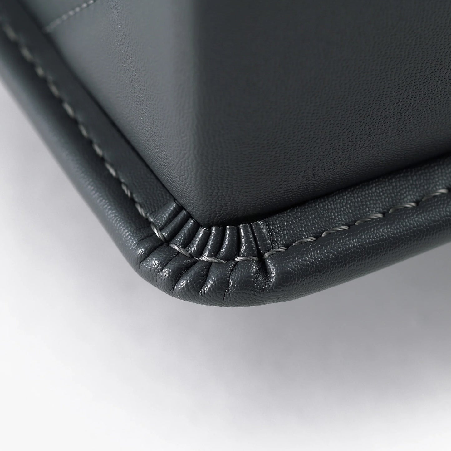 Close-up of Japanese randoseru backpack corner showing fine black leather stitching detail