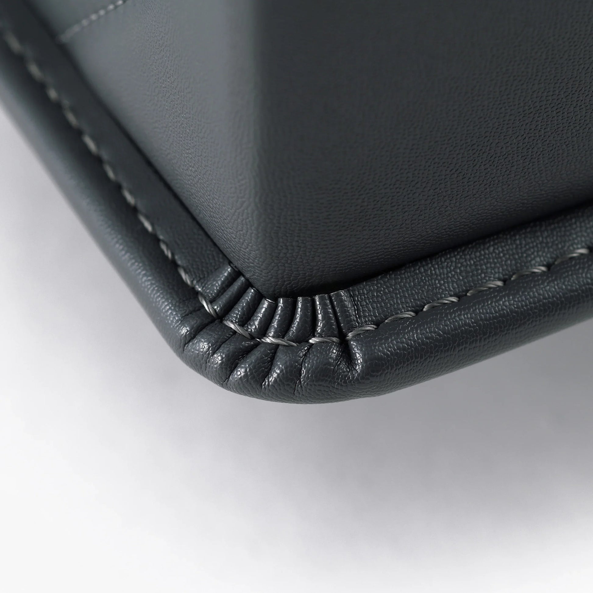 Close-up of Japanese randoseru backpack corner showing fine black leather stitching detail